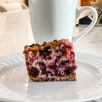 A slice of the Easy Blackberry Coffee Cake Recipe in front of a mug