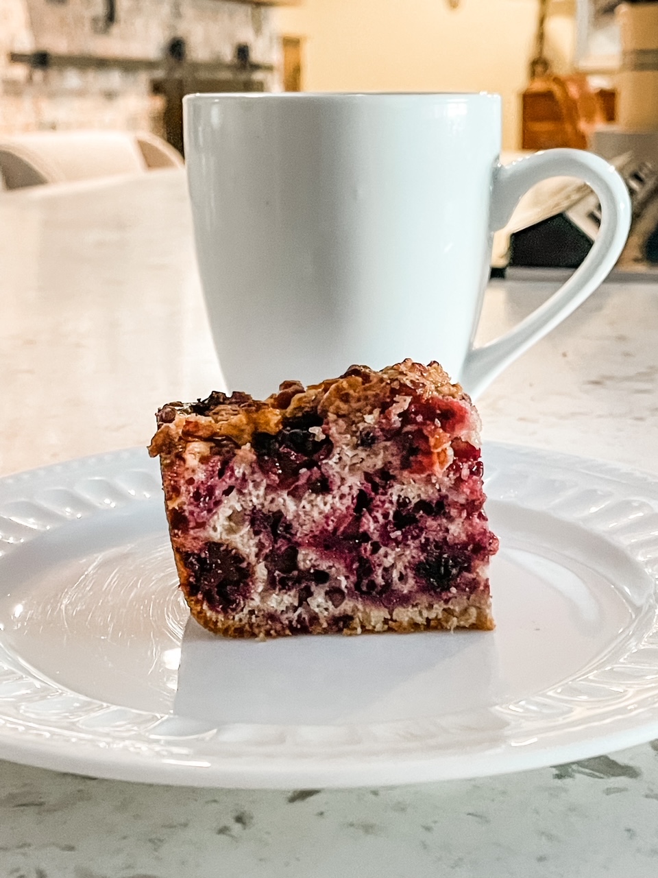 A slice of the Easy Blackberry Coffee Cake Recipe in front of a mug