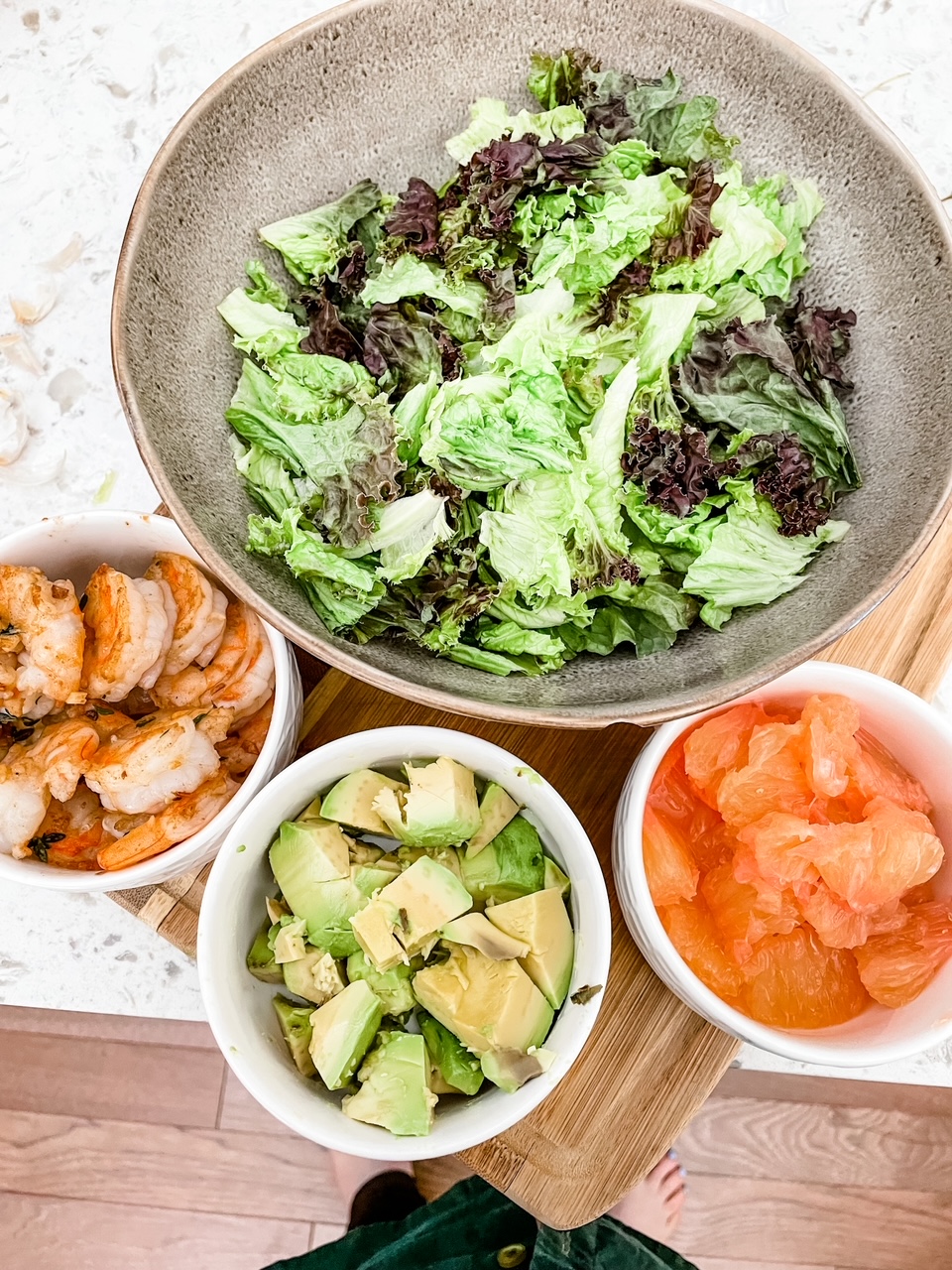 Other ingredients in small dishes - shrimp, avocado, and cut up grapefruit