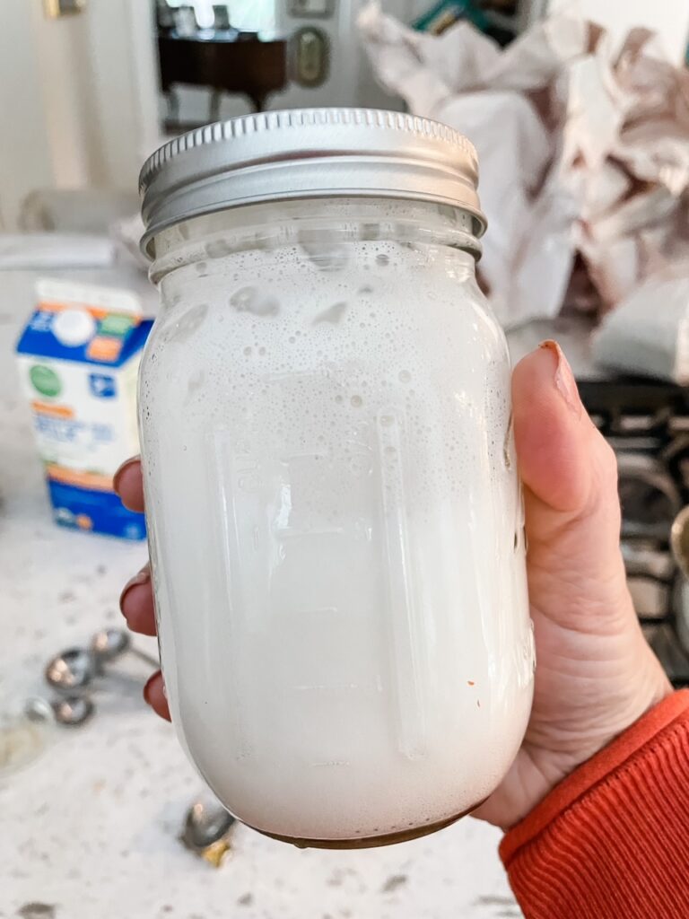 Shaking the milk in a jar to create foam