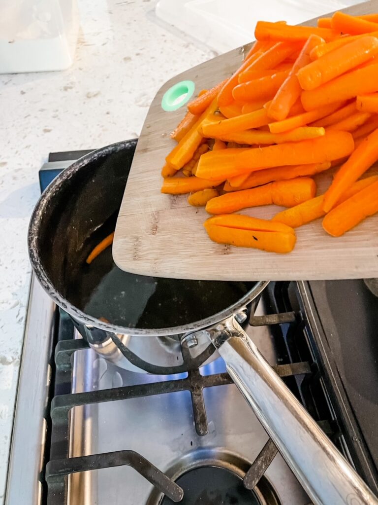 The sliced carrots being poured into the brine