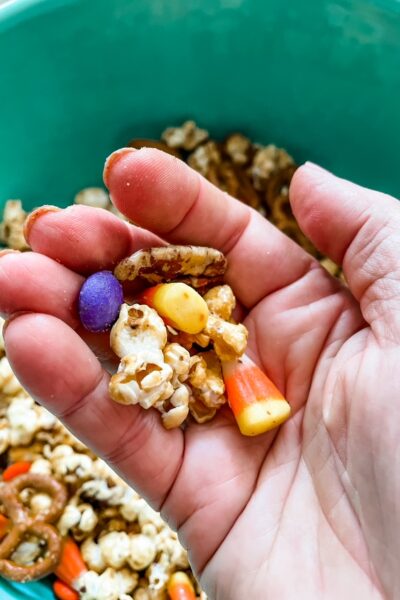 A hand holding up some of the Easy Halloween Caramel Corn Recipe