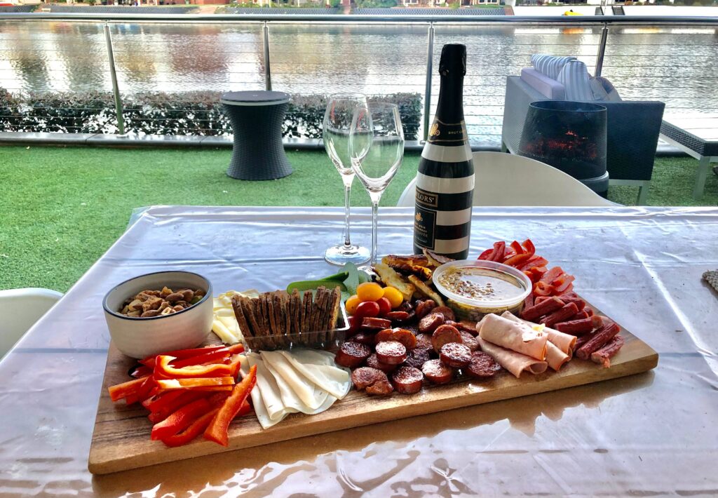 A platter of crakcers, veggies, and meats from Costco