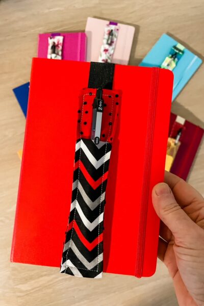 A red notebook with one of the DIY Pen Pouches