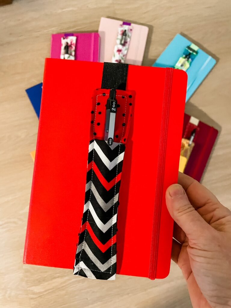 A red notebook with one of the DIY Pen Pouches