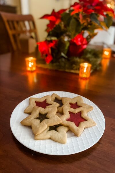 A plate of the Stained Glass Cutout Sugar Cookies in front of a Christmas tree
