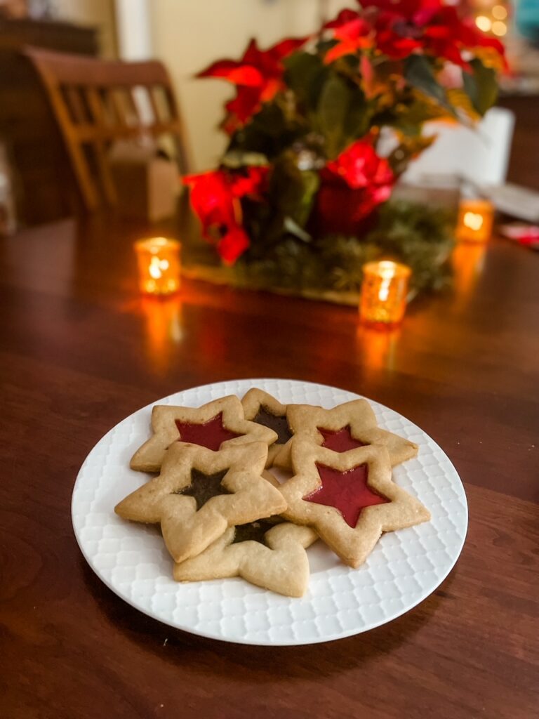 A plate of the Stained Glass Cutout Sugar Cookies in front of a Christmas tree
