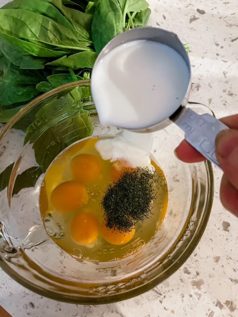 A bowl with cracked eggs, pepper, and salt being poured in