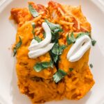 The finished Sweet Potato and Roasted Vegetable Enchiladas with a dollop of sour cream