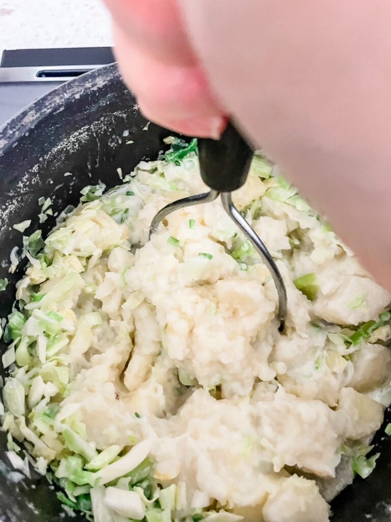 Mashing the potatoes into the butter and herbs mixture