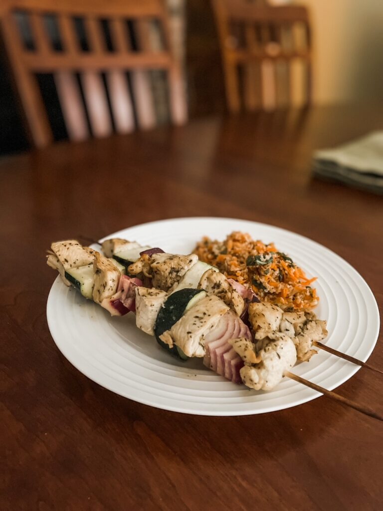The finished Easy Mediterranean Chicken Skewers plated with rice