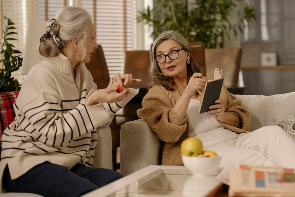 Two woman discussing a book one is reading