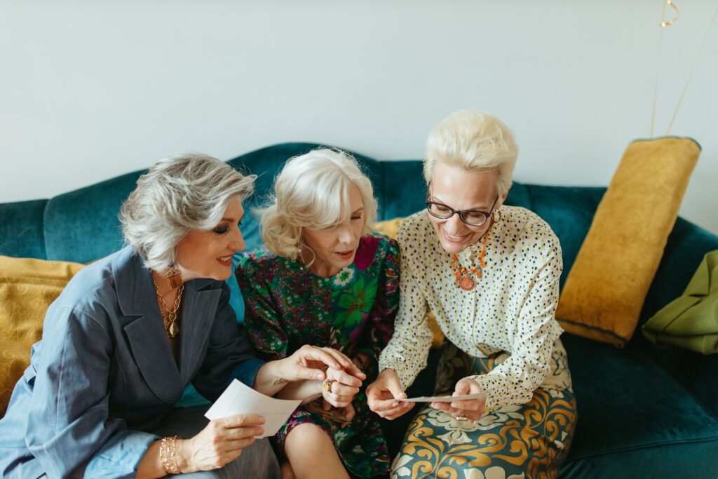 A group of ladies sitting on a couch and looking at a photo