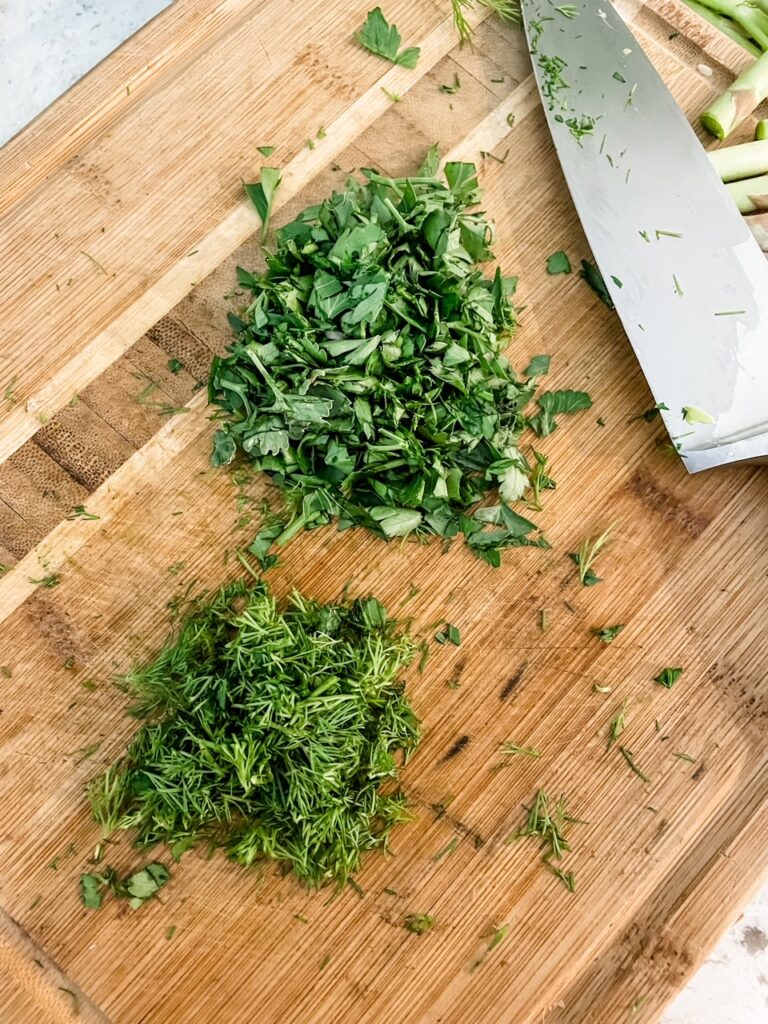 The chopped fresh herbs on a cutting board