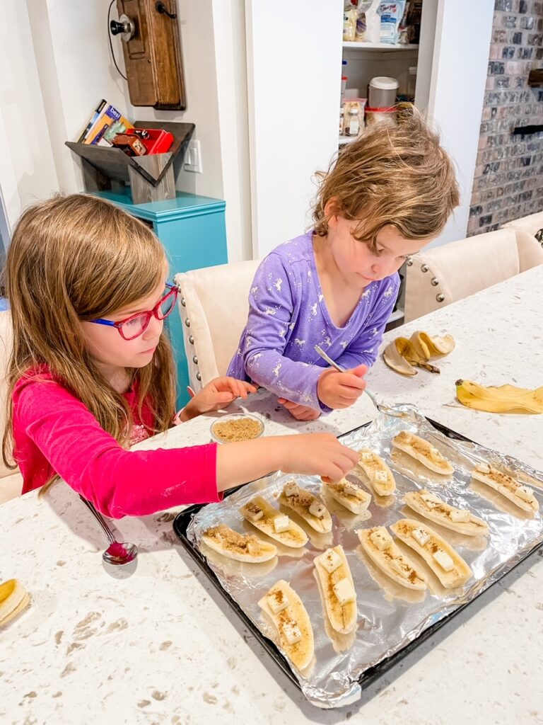 Marie's grandkids sprinkling toppings onto their banana slices
