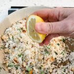 A lemon slice being squeezed over the Lemon Herb Rice Pilaf