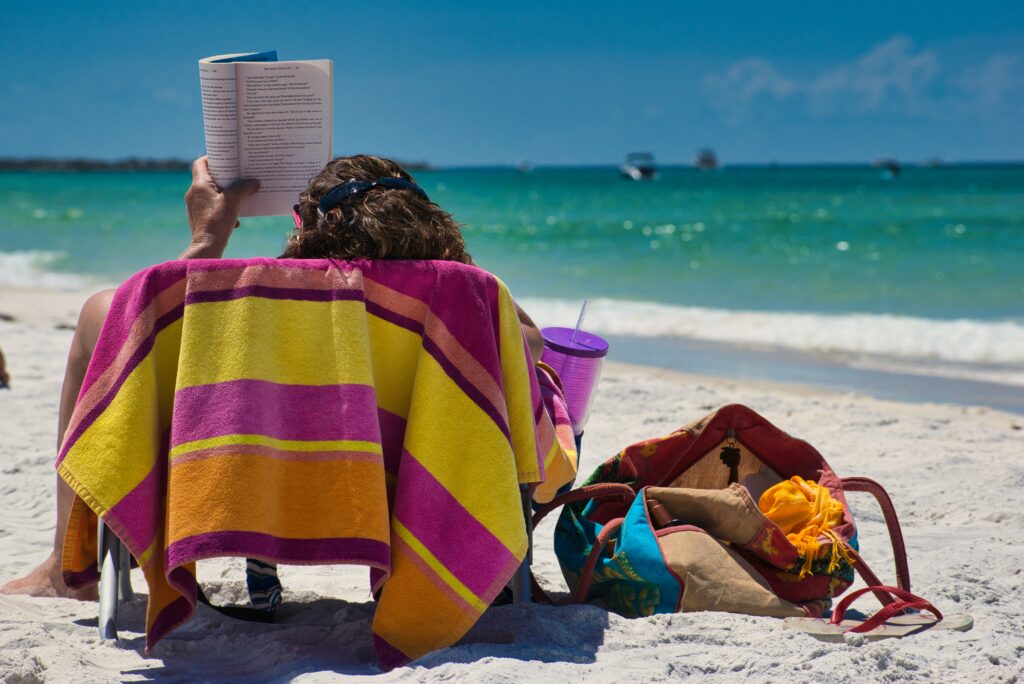 A woman reading a book on a beach