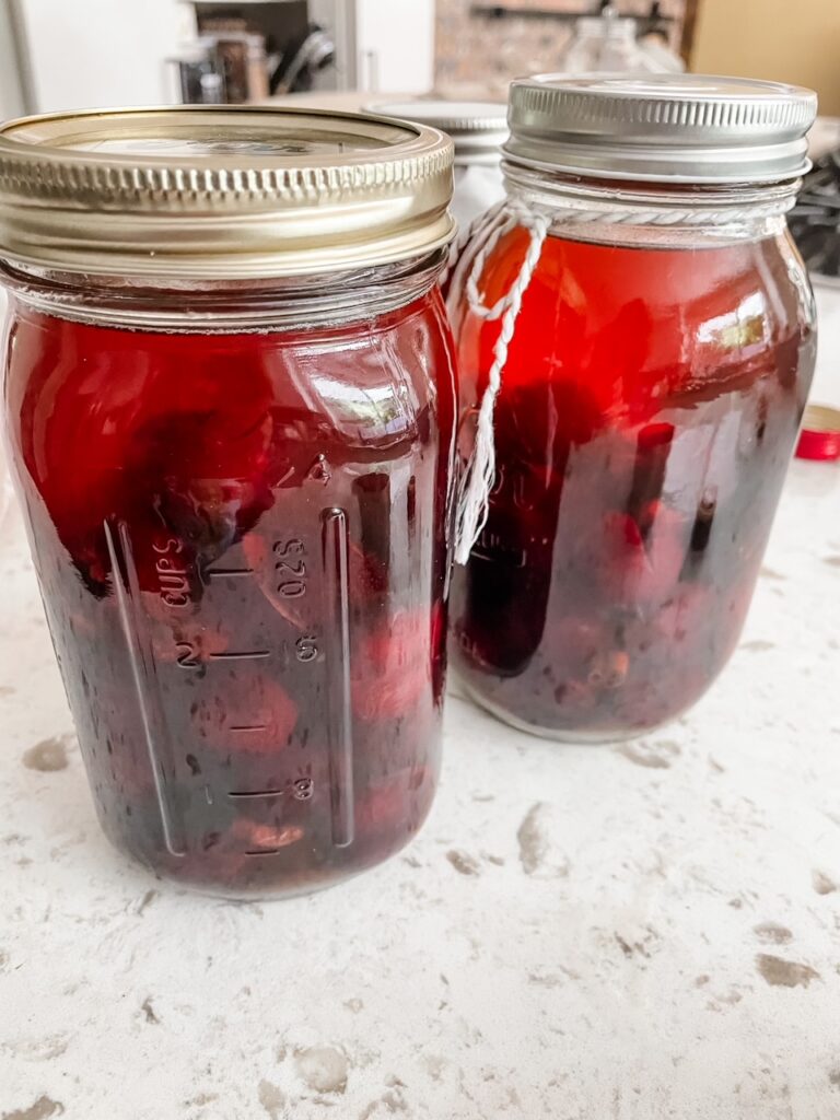 The jars with cherries and liquor poured in and sealed