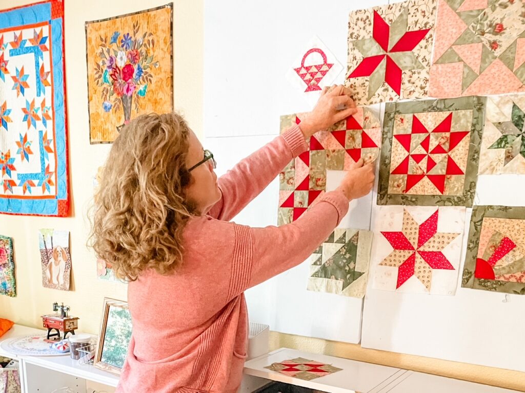 Marie hanging a square on her Easy DIY Quilting Design Wall Board