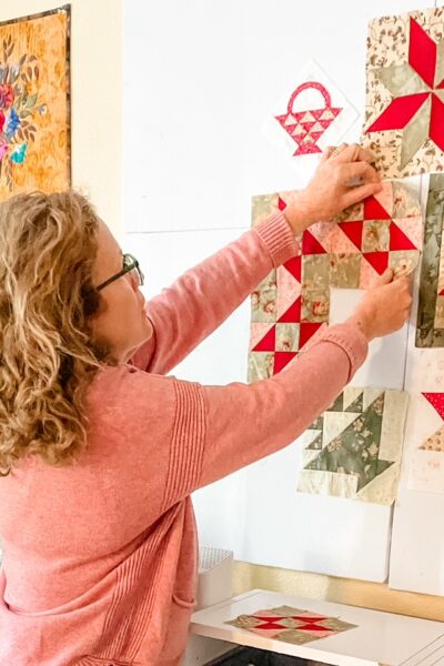 Marie hanging a square on her Easy DIY Quilting Design Wall Board
