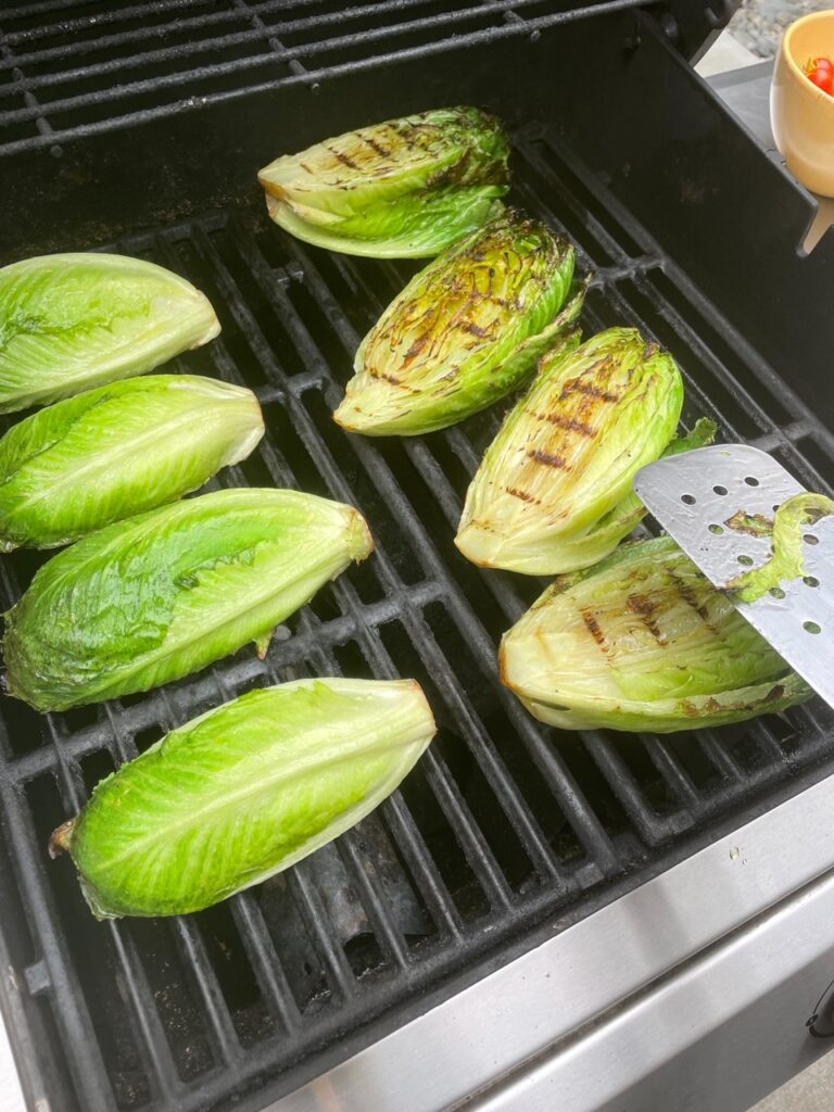 The sliced romaine being grilled