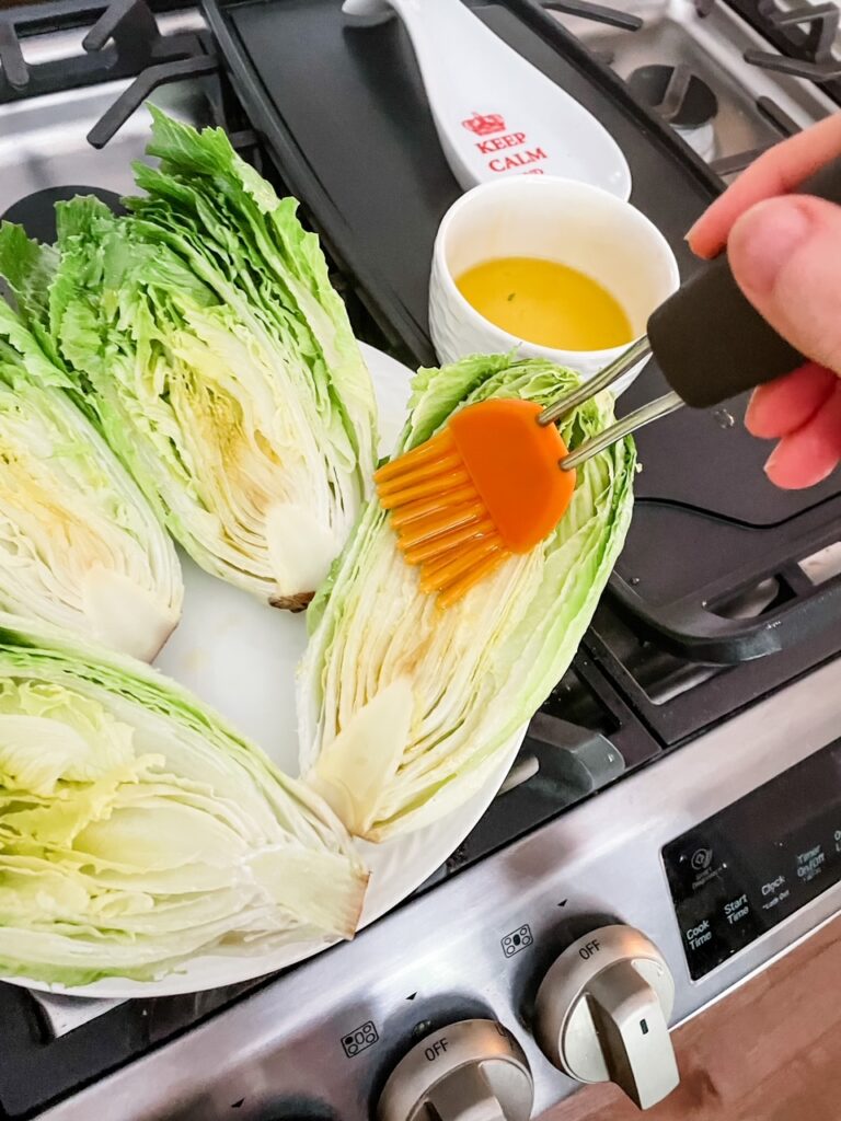The romaine cut in half and being brushed with olive oil