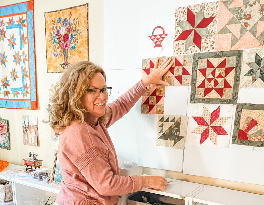 Marie hanging a square on her Easy DIY Quilting Design Wall Board