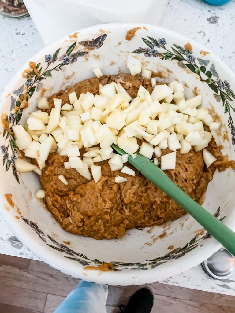 The cubed apples being mixed into the batter