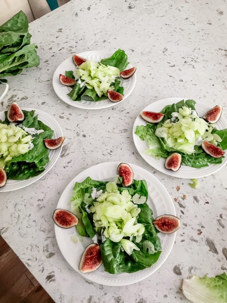 Four of the finished fall salads, plated and set on a counter