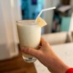 The finished Hawaiian-Inspired Smoothie in a glass being held up