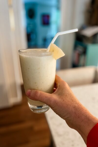 The finished Hawaiian-Inspired Smoothie in a glass being held up