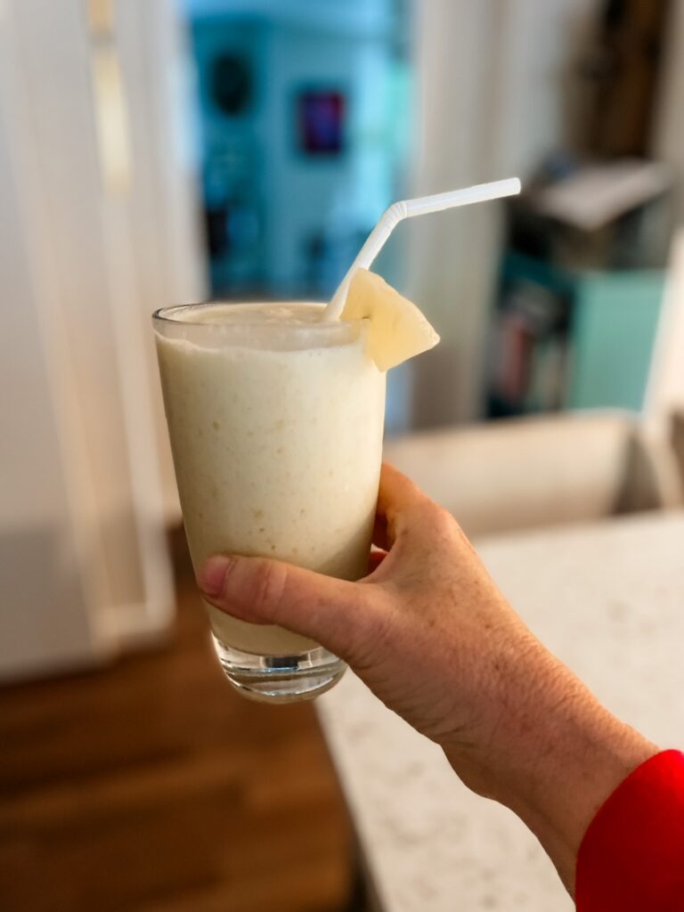 The finished Hawaiian-Inspired Smoothie in a glass being held up