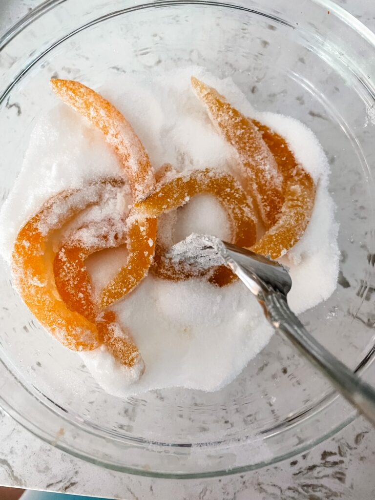 The blanched and syruped peels being tossed in sugar