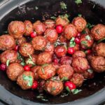 Te Easy Cranberry Mustard Slow Cooker Meatballs in a slow cooker with fresh cranberries