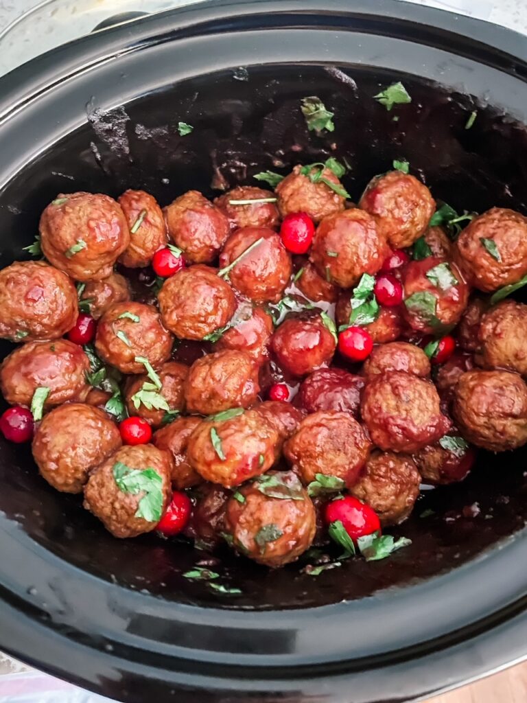 Te Easy Cranberry Mustard Slow Cooker Meatballs in a slow cooker with fresh cranberries