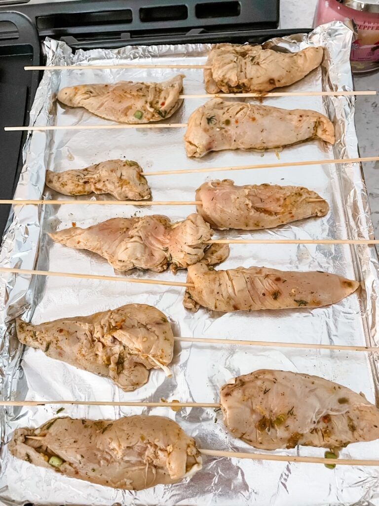 The marinaded chicken on a baking sheet