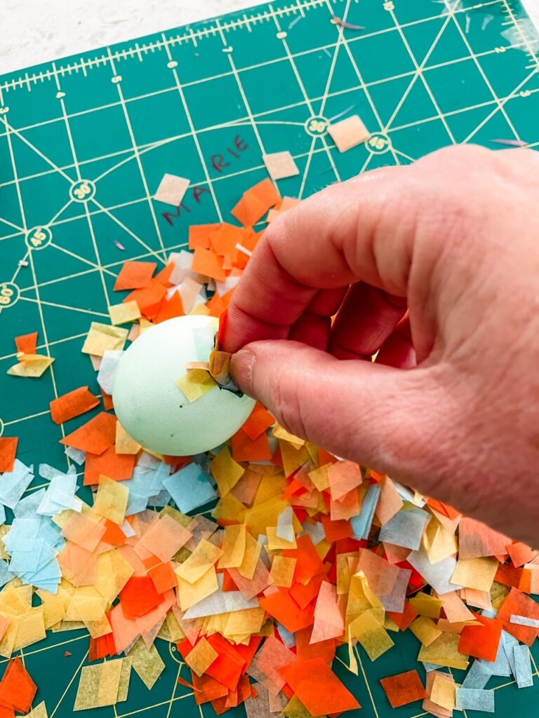 The confetti pieces being placed in the egg shell