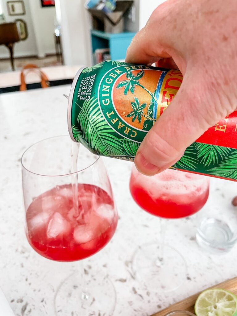 The ginger beer being poured into the glass