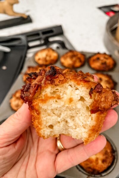 One of the finished Pineapple Orange Muffins being held up with a bite taken from it