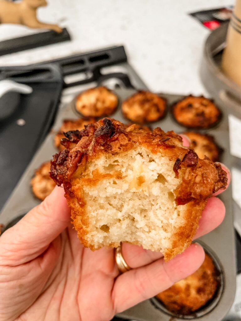 One of the finished Pineapple Orange Muffins being held up with a bite taken from it