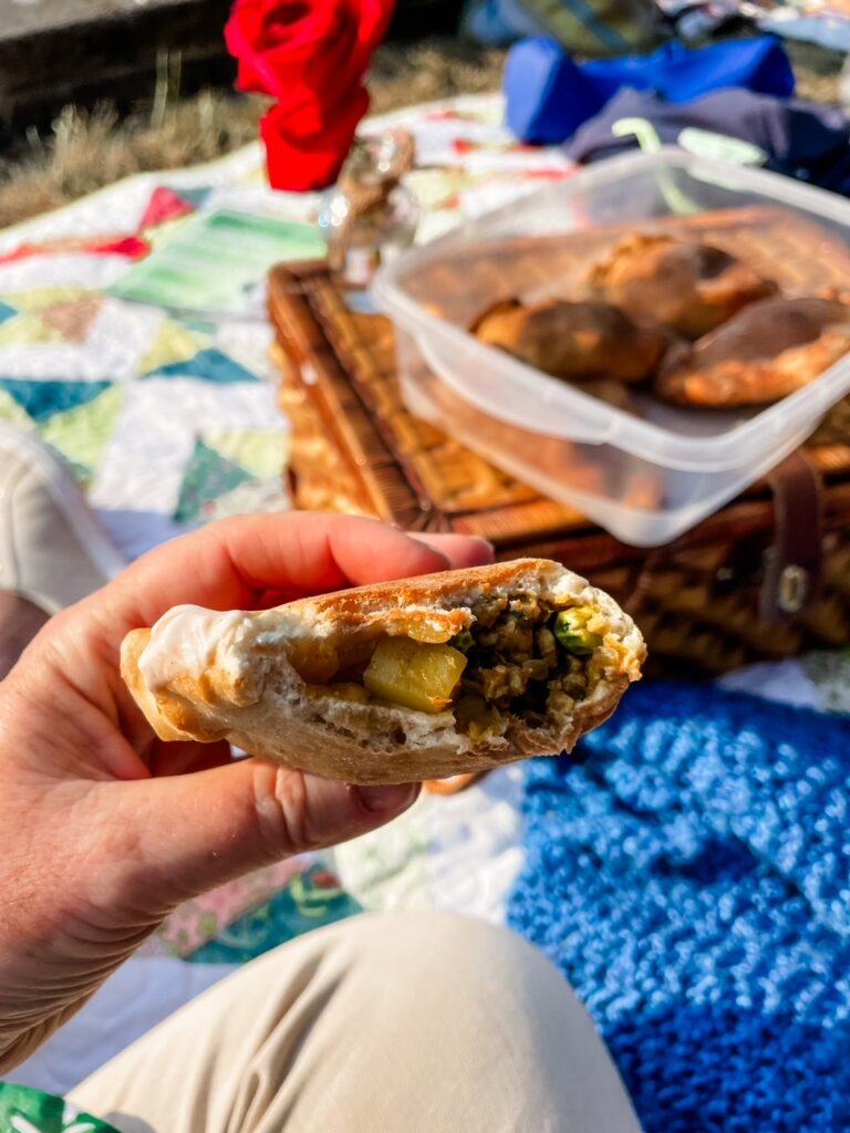 Marie eating one of the Easy Chicken Curry Hand Pies at a picnic