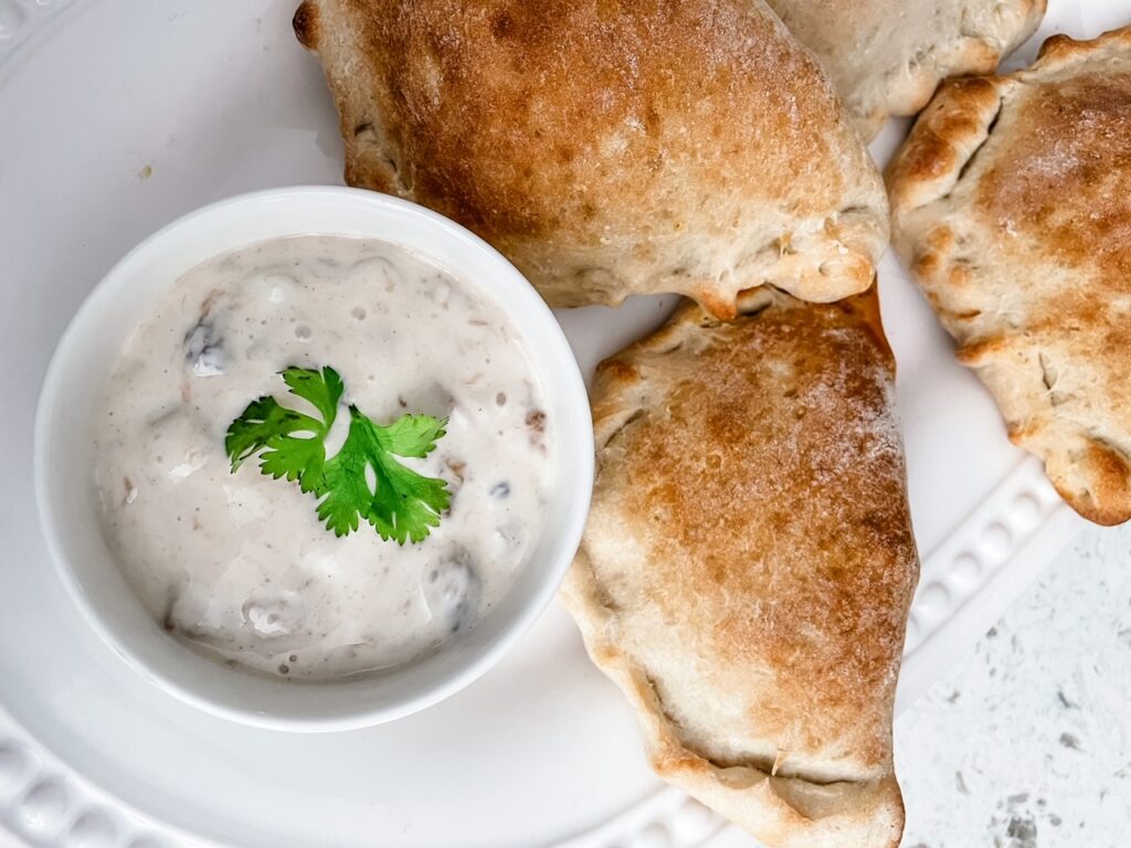 The finished Easy Chicken Curry Hand Pies alongside some dipping sauce