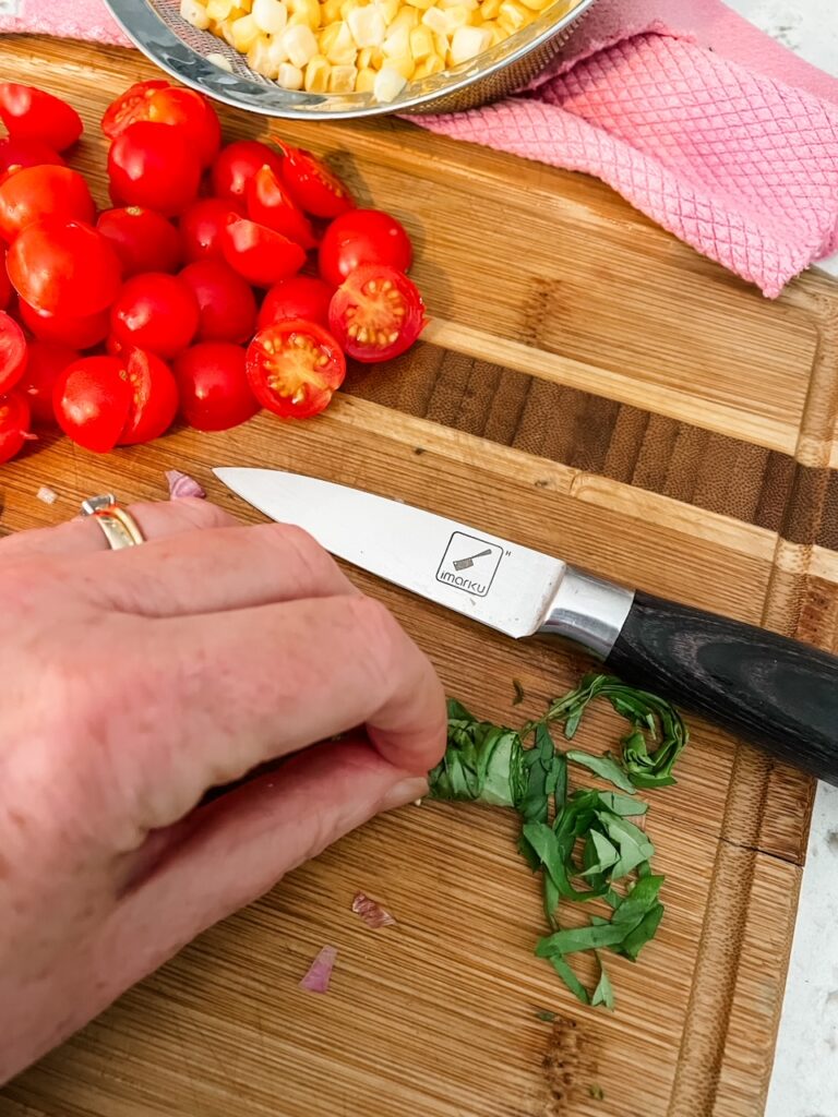 The basil being chopped chiffonade style