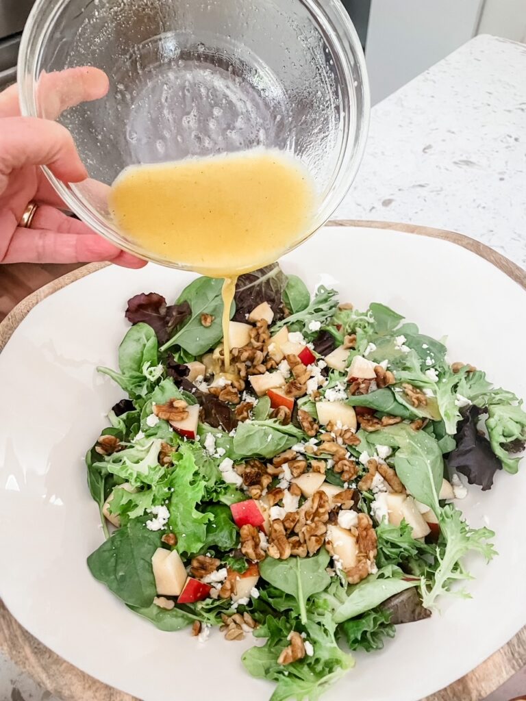 The finished Fall Apple and Gorgonzola Salad having dressing poured over it