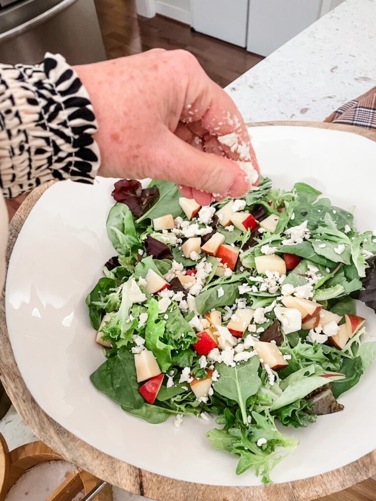 Crumbling the Gorgonzola cheese over the salad