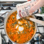 Pouring in low-fat coconut milk into the soup