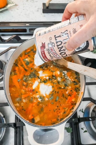 Pouring in low-fat coconut milk into the soup