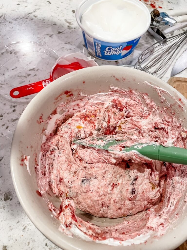 The cranberry sauce and whipped cream being folded together