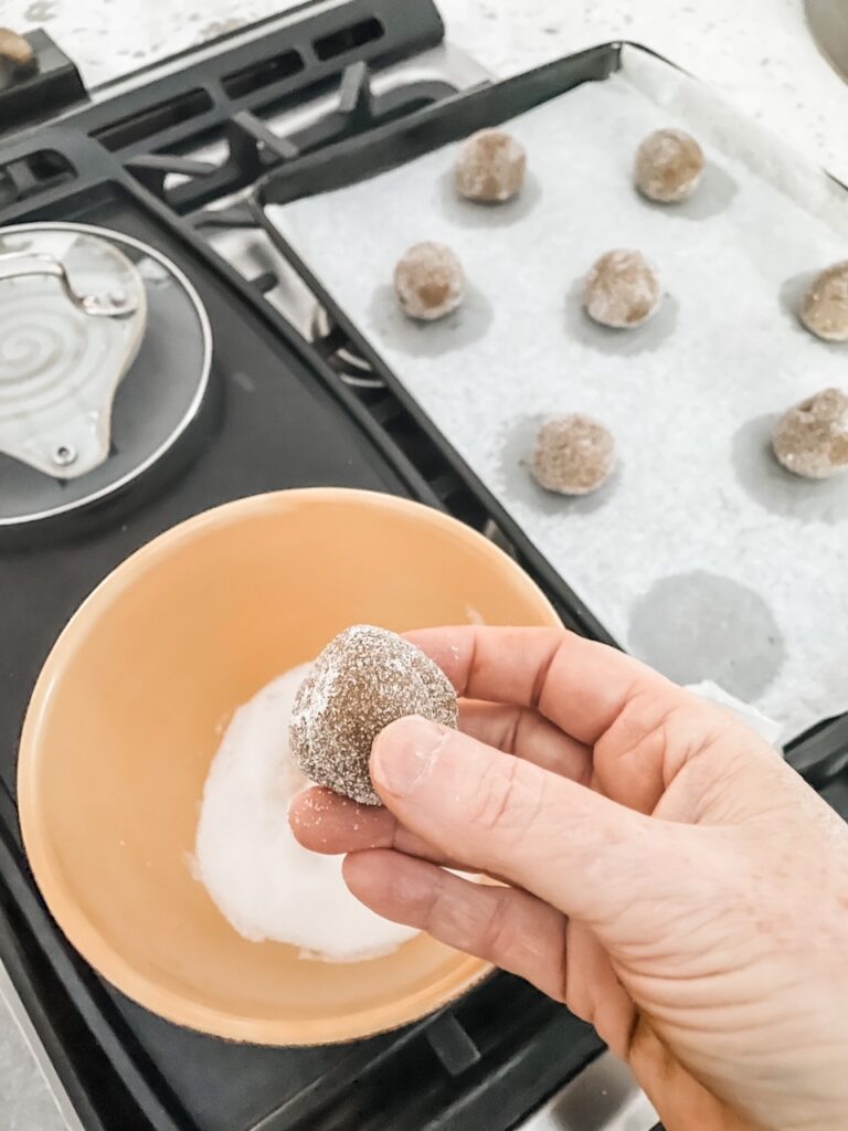 The ball of dough being rolled in sugar