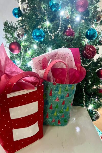 The finished DIY Fabric Gift Bags for Christmas in front of a Christmas tree